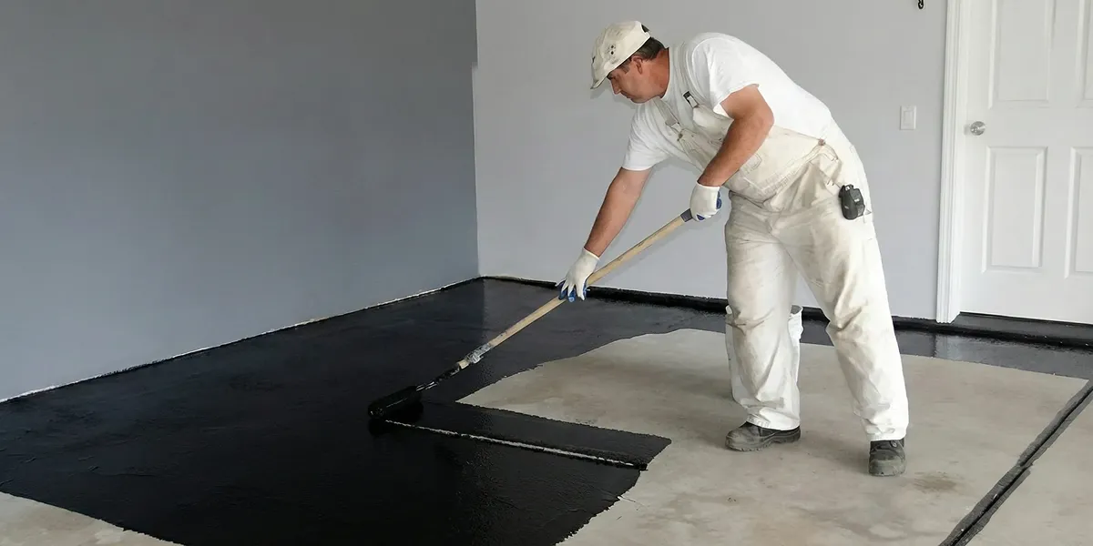 basement waterproofing professional applying waterproof coating to protect a basement floor in Myrtle Beach, SC