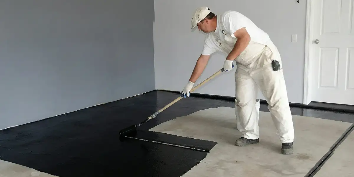 basement waterproofing professional applying waterproof coating to protect a basement floor in Myrtle Beach, SC