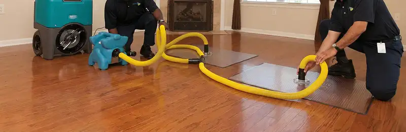emergency water removal technicians extracting standing water from a home using professional equipment in Myrtle Beach, SC
